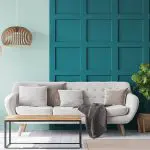 A living room with two contrasting wall finishes — mint green and deep teal board-and-batten — showing how to choose the right paint finish for interior walls