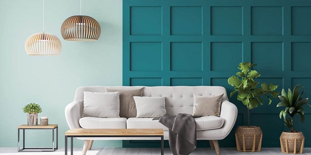 A living room with two contrasting wall finishes — mint green and deep teal board-and-batten — showing how to choose the right paint finish for interior walls